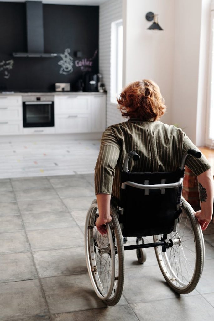 pexels-photo-4064426 Woman in wheelchair moving around a modern kitchen, showcasing independence and domestic life.